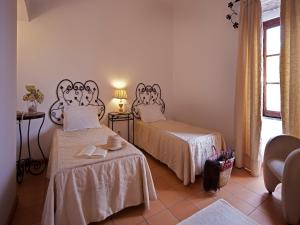 a room with two beds and a window at Betica Hotel Rural in Pias