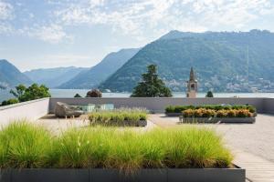 a garden with mountains in the background at Hilton Lake Como in Como