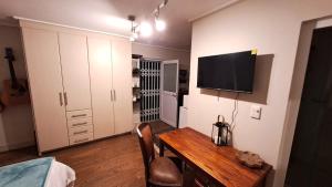 a room with a table and a television on a wall at 29 Cutty Sark in Plettenberg Bay