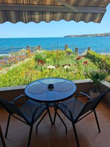 a patio with a table and chairs and the ocean at Guest Rooms Skalite in Sozopol