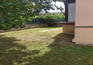 a yard with green grass and a building at Mogro Las Dunas - Relax Total en Apartamento con Jardín in Miengo