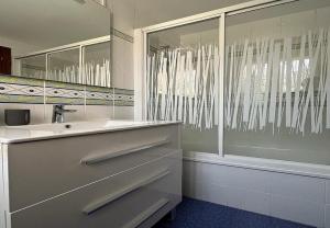 a white bathroom with a sink and a shower at Mogro Las Dunas - Relax Total en Apartamento con Jardín in Miengo