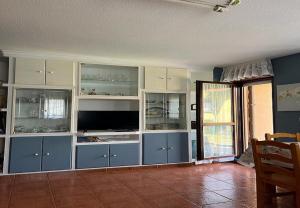 a living room with blue and white cabinets and a television at Mogro Las Dunas - Relax Total en Apartamento con Jardín in Miengo +21 photos