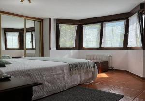 a bedroom with a large bed in a room with windows at Mogro Las Dunas - Relax Total en Apartamento con Jardín in Miengo