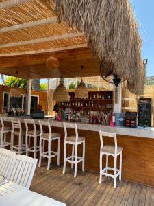 a bar on a deck with white stools at Melengeç Otel Türkbükü in Golturkbuku