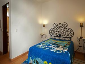 a bedroom with a bed with a blue blanket at Betica Hotel Rural in Pias