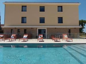 カブリエにあるibis Styles Cabriès Aix-en-Provence TGVの椅子とプールが備わる建物
