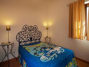 a bedroom with a bed with a blue comforter at Betica Hotel Rural in Pias
