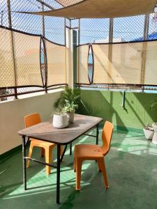 a table and two orange chairs and a table and chairs at 326 Podtel at The Breakie Bar in Bangkok +29 photos