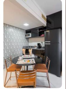 a kitchen with a table and chairs and a refrigerator at Lê premier in São Paulo
