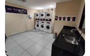 a bathroom with two washing machines and a sink at Lê premier in São Paulo