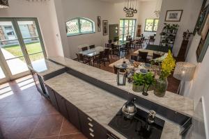 a kitchen with a counter top and a dining room at Oszter Udvarház in Kékkút