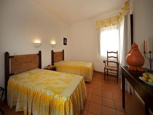 a hotel room with two beds and a window at Betica Hotel Rural in Pias