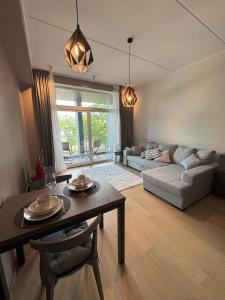 un soggiorno con un tavolo e un divano di Riverside Retreat - Cozy Central Stay in Pärnu a Pärnu