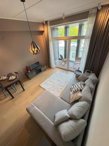 un soggiorno con un divano e una grande finestra di Riverside Retreat - Cozy Central Stay in Pärnu a Pärnu