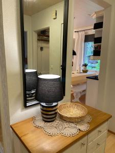 eine Lampe auf einem Tisch in einem Badezimmer mit einem Spiegel in der Unterkunft Villa Väinölä, tilaa rauhoittua in Alavus + 45 Fotos