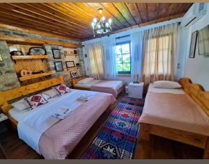 a bedroom with two beds and a wooden ceiling at "Villa 70" Guesthouse in Gjirokastër