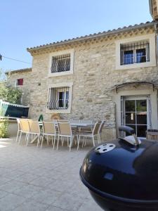a house with a table and chairs and a building at Évasion de charme, maison authentique et spa privé in La Baume-de-Transit