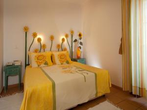 a bedroom with a yellow bed with flowers on it at Betica Hotel Rural in Pias