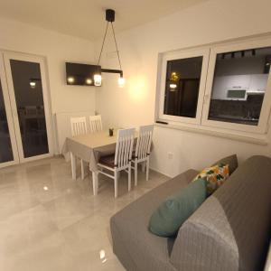 a living room with a couch and a table and chairs at Apartman Franka in Labin +1 photo