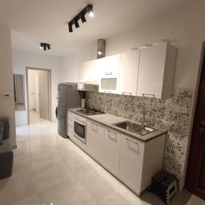 a kitchen with white cabinets and a stainless steel refrigerator at Apartman Franka in Labin