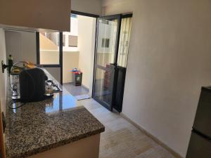 a kitchen with a counter and a door to a room at Bab fes Appartement 2 pièces à Aïn Sebaâ Casablanca in Aïn Sebaa
