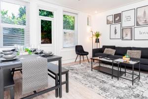 een woonkamer met een zwarte bank en een tafel bij Modern 5-bed - Sleeps 10-walk To Centre & Parking! in Southampton