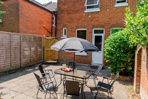 a patio with a table and chairs with an umbrella at Modern 5-bed - Sleeps 10-walk To Centre & Parking! in Southampton