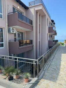 an apartment building with balconies and a walkway at Sinemorets Blue apartments in Sinemorets