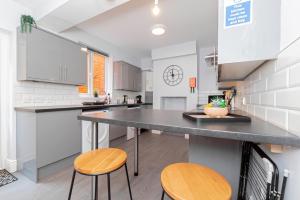 a kitchen with a large counter and two stools at Modern 5-bed - Sleeps 10-walk To Centre & Parking! in Southampton