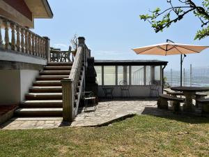 a patio with stairs and a table and an umbrella at VILLA OSTRERA in Suances +17 photos