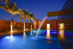 a swimming pool with a fountain in front of a building at Dar Syada Boutique Hotel Marrakech in Marrakech