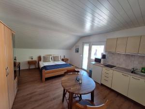 a room with a bed and a kitchen with a table at Apartmani Mate in Omiš