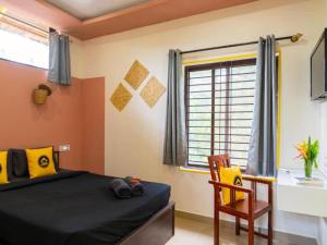 une chambre avec un lit, une chaise et une fenêtre dans l'établissement The Hosteller Chikmagalur, à Chikmagalur