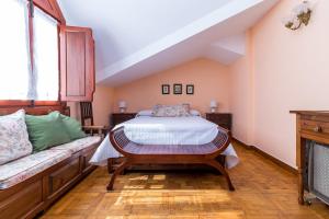 a bedroom with a bed and a couch at Encantadora casa con jardín cerca de Santillana del Mar in Oreña +23 photos