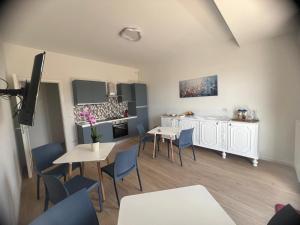 a living room with tables and chairs and a kitchen at FLAIC b&b in Pergusa