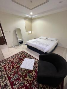a bedroom with a bed and a chair and a rug at AL-Diyafh Hotel in Az Zāhir +23 photos