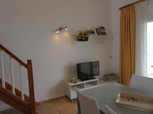 a living room with a table and a television at Astbury Apartments Ses Basses in Es Caló