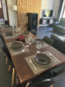 ein Holztisch mit Tellern und Weingläsern darauf in der Unterkunft The Little House of Spa in Spa