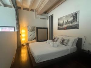 una camera da letto con un letto bianco con un quadro sul muro di RED LOFTY Milano- Loft moderno comodo per Ippodromo, San Siro, Rho Fiera-MiCo e Politecnico, parking a Milano