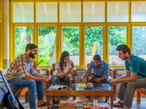 a group of people sitting around a table in a room at The Hosteller Chikmagalur in Chikmagalūr
