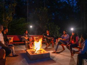 チクマガルールにあるThe Hosteller Chikmagalurの夜、火の周りに座っている人々のグループ