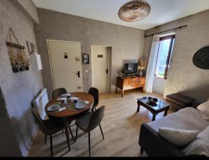 a living room with a table and a couch at GARDENHILL familly 2 chambres in Argelès-Gazost
