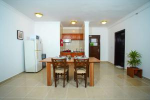 a kitchen with a table and chairs and a refrigerator at La Villa Inn Hotel Apartment in Doha +7 photos
