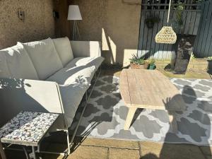 a couch and a wooden table on a patio at Peaceful and Stylish Garden Flat Close to Transport and City Centre in Glasgow