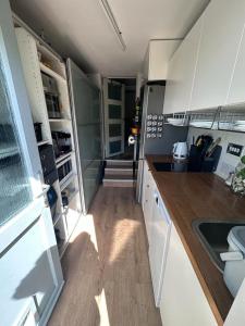 a small kitchen with white cabinets and a wooden floor at Peaceful and Stylish Garden Flat Close to Transport and City Centre in Glasgow