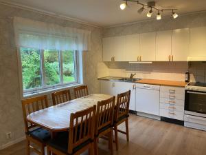 a kitchen with a table and chairs and a sink at Villa Next to the Forest in Tingsryd +28 photos
