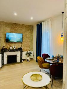 a living room with two tables and a fireplace at Appartement hyper centre Balcon in Périgueux