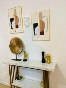 a room with a table with a fan and two pictures at Appartement hyper centre Balcon in Périgueux