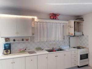 a kitchen with white cabinets and a sink at Thanos House - Σπίτι στην εξοχή in Mirsinokhórion